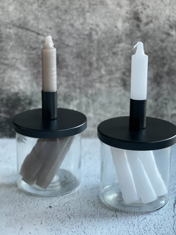 Glazenpot met kaarsen en een kandelaar op de deksel